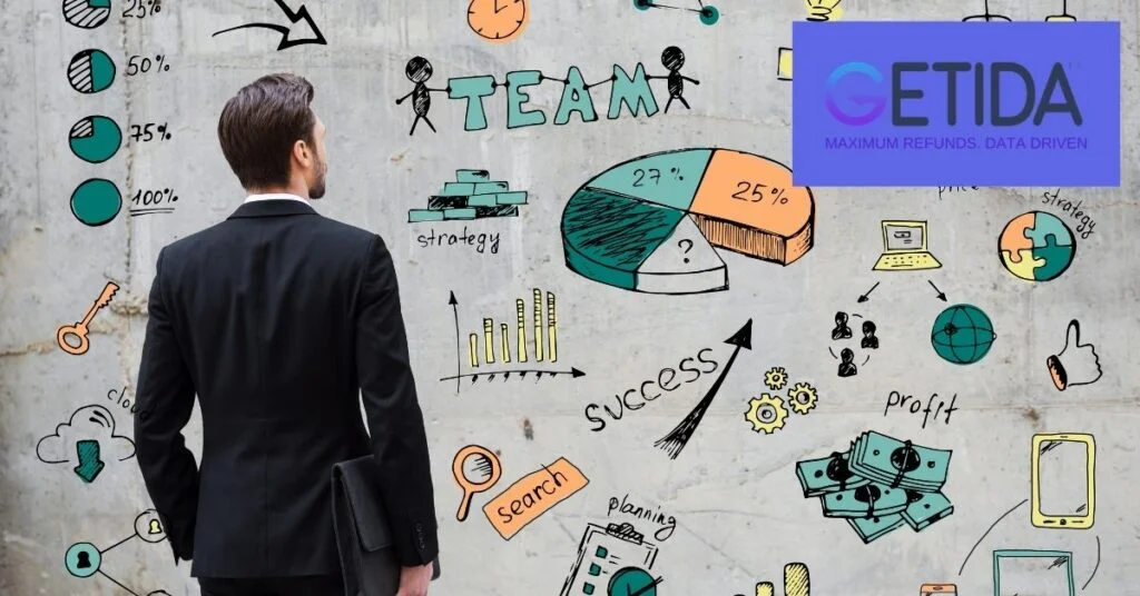 Man in suit viewing wall with colorful business strategy doodles and "GETIDA" logo.