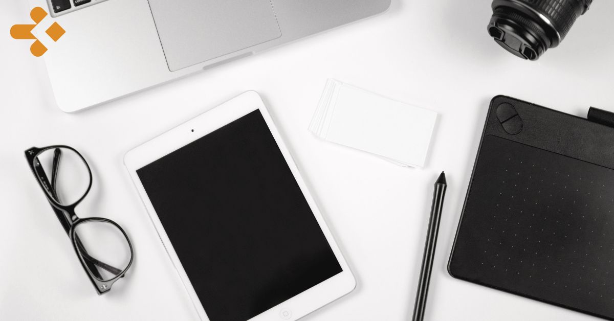 Overhead image of ipad, glasses, computer, and camera