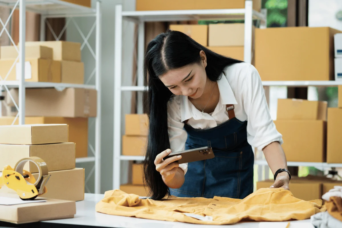 E-commerce seller documenting products for online sale using her smartphone.